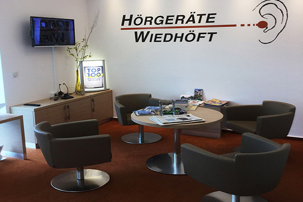 Moderner Wartebereich eines Hörgeräteakustikers mit vier Sesseln und Infobroschüren.