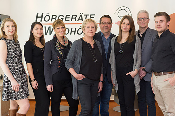 Das Team von Hörgeräte Windhövel steht gemeinsam im modernen Fachgeschäft.